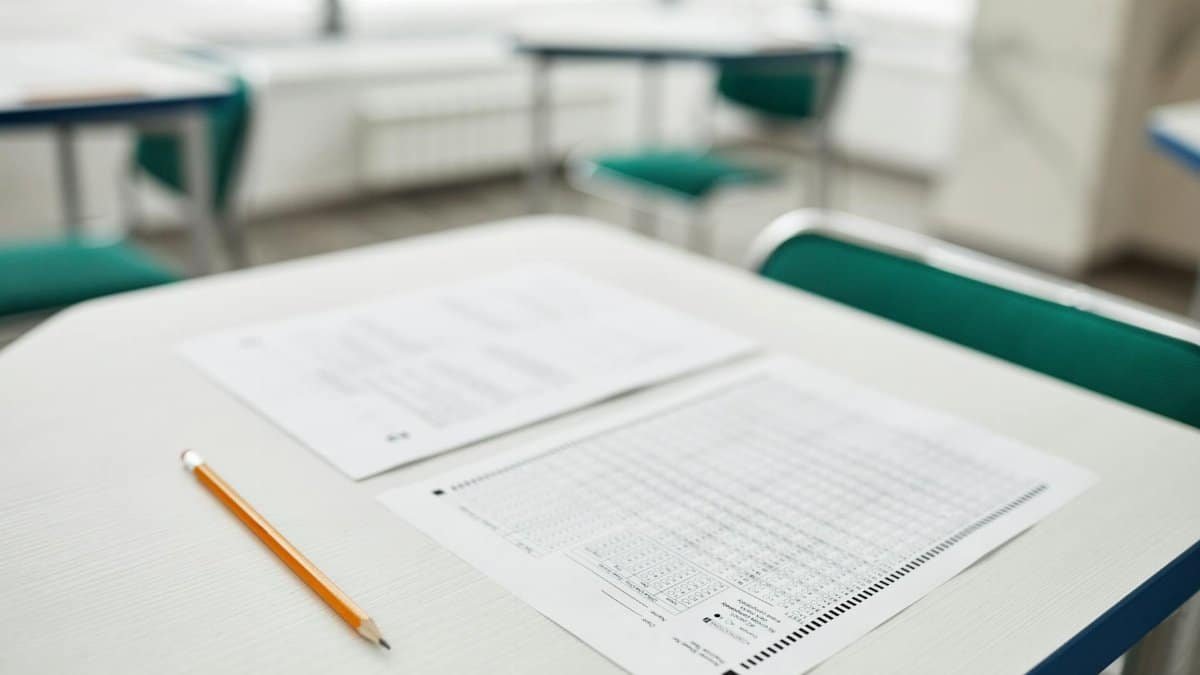 Close-up of exam papers and a pencil on a classroom desk, ready for a test.