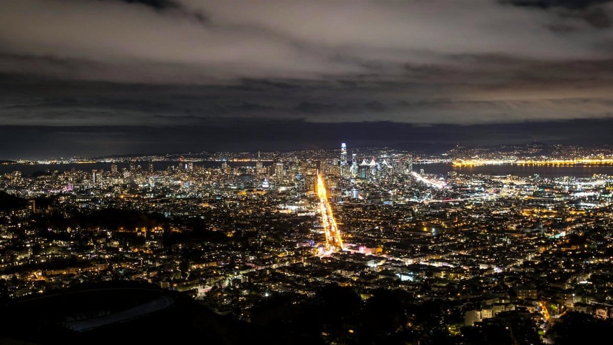 A breathtaking aerial view of San Francisco's skyline at night with city lights aglow and the famous streets illuminated.