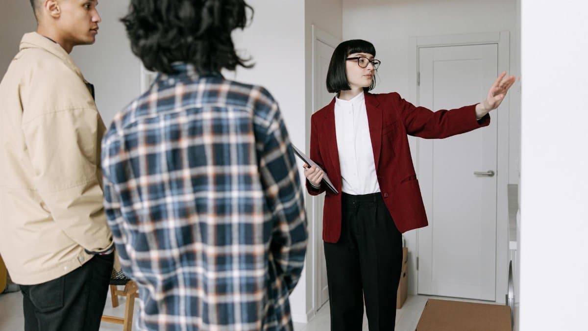 Real estate agent presenting an apartment to potential buyers during a property tour.