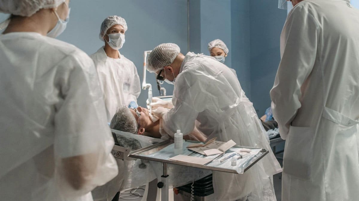 Medical professionals performing surgery in a modern operating room, focused on patient care.