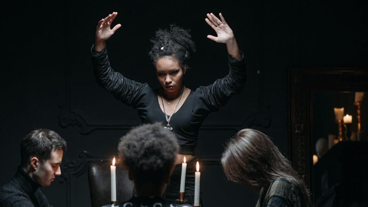 A spiritual seance gathering with participants around a candlelit table, engaging in mysticism.