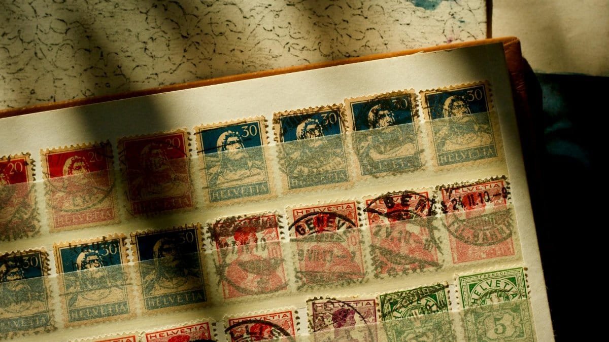 A collection of vintage Swiss stamps displayed in an album under warm sunlight, showcasing historical philately.