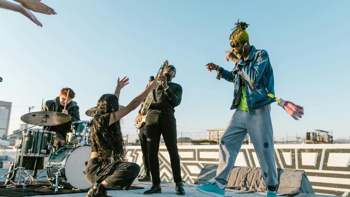 Lively rooftop performance featuring a diverse band playing music on a sunny day.
