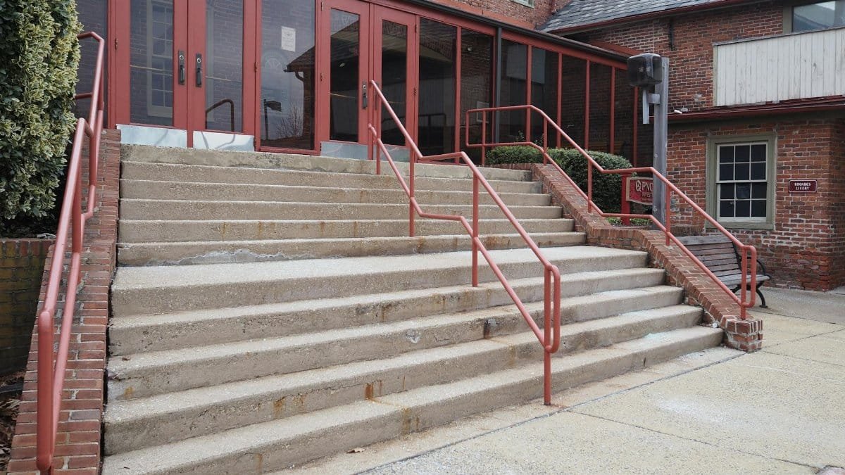 Red-brick building entrance with concrete steps and metal railings in Doylestown, PA.