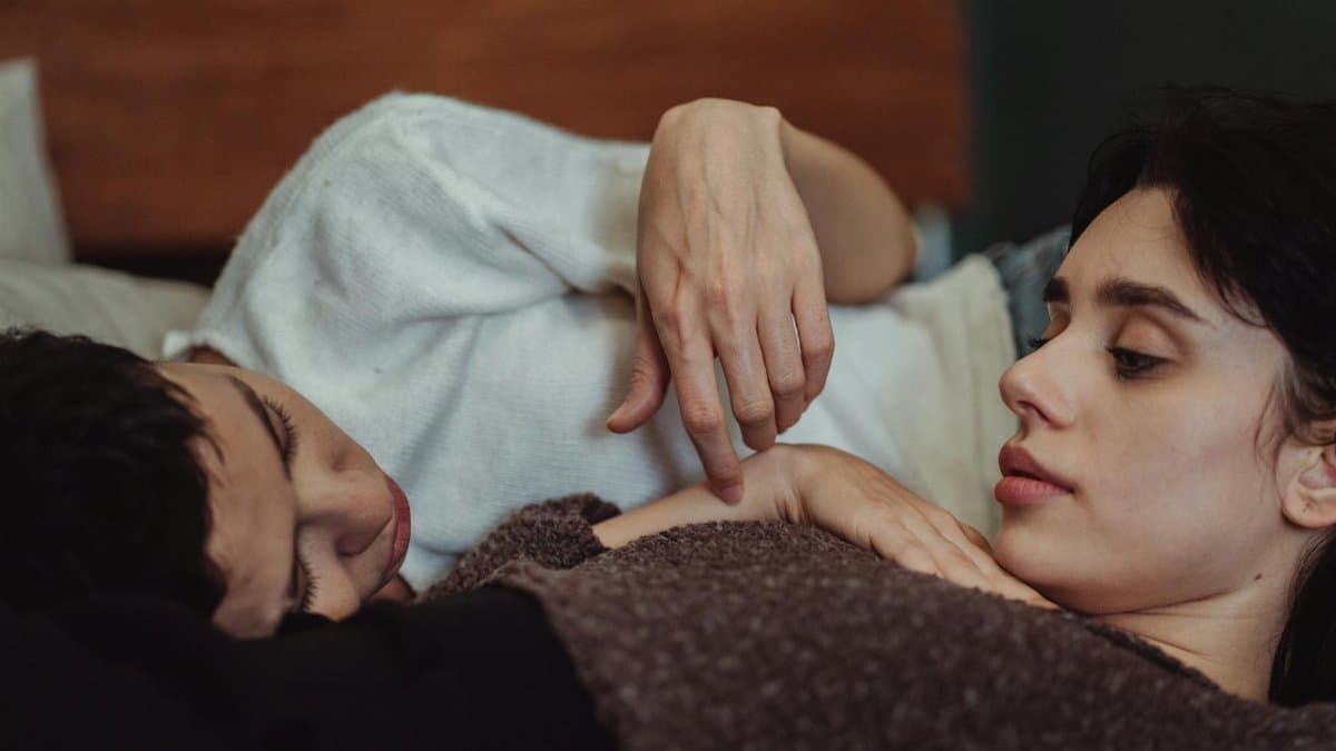 A tender scene of a couple relaxing together on a bed, reflecting love and intimacy.