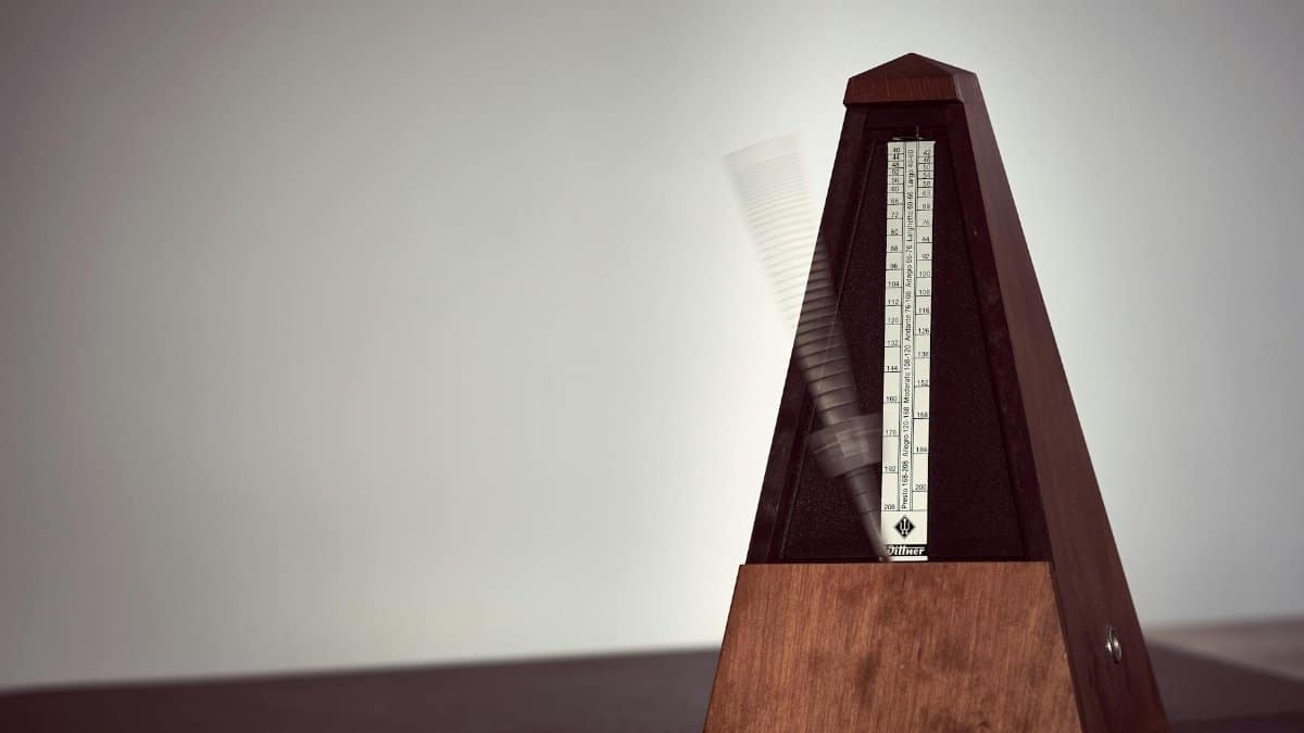 A close-up image of a wooden metronome in motion, symbolizing precision in music practice.