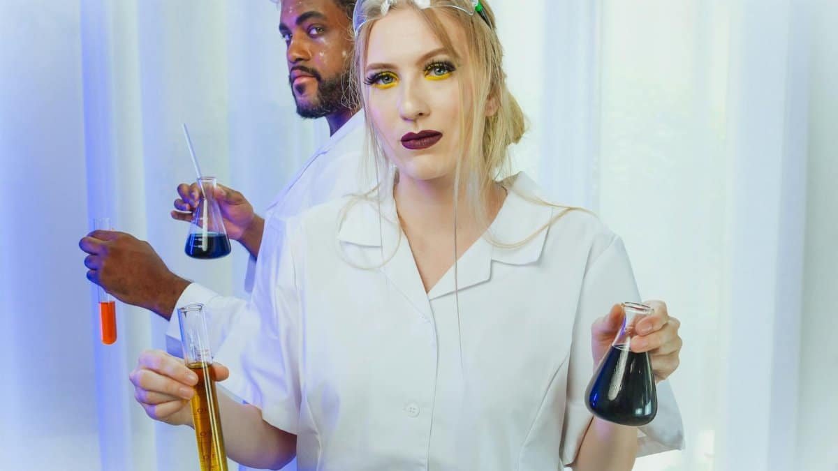 Two scientists in lab coats conducting a chemistry experiment with various liquids.