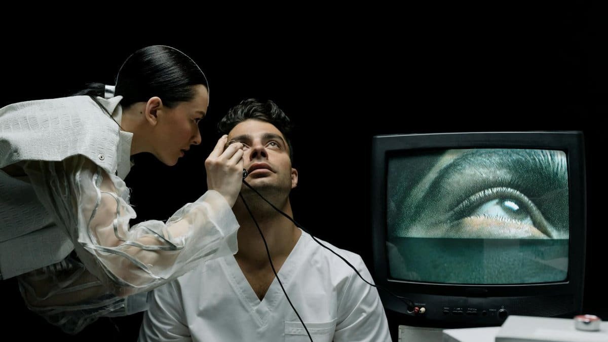Technician performing eye exam using advanced medical technology with real-time monitoring.