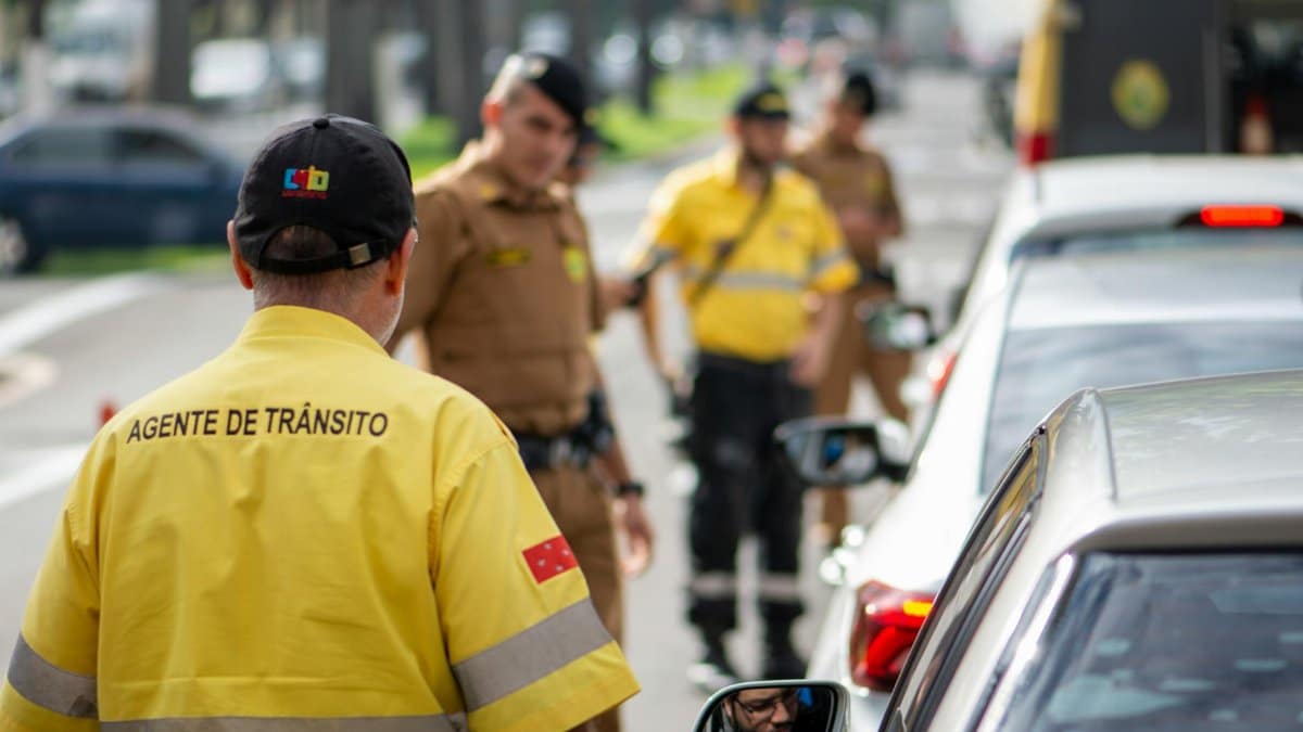 Traffic agent in bright uniform managing vehicles on a busy Londrina street.