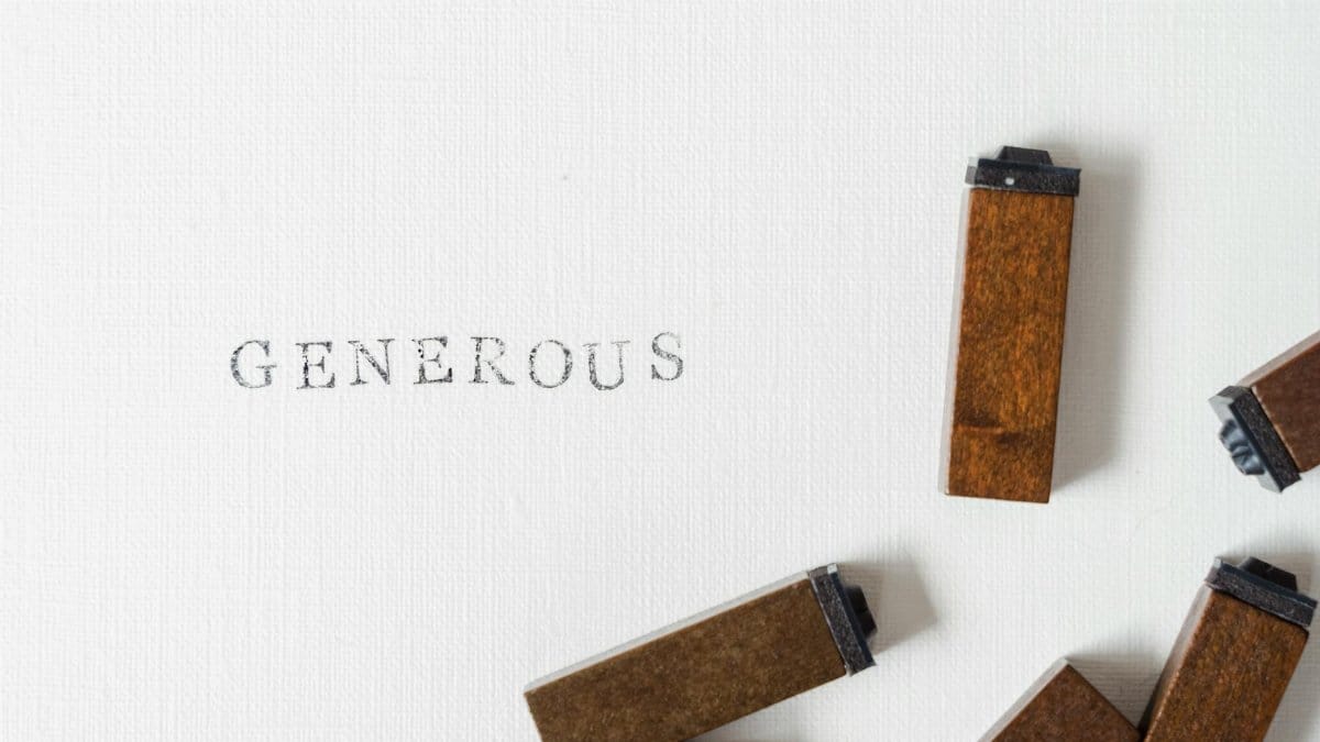 A minimalist photo of wooden blocks spelling 'Generous' on a textured background.