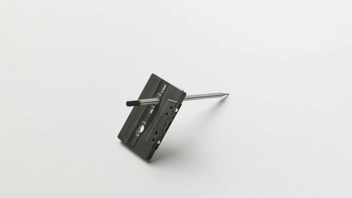 Classic cassette tape pierced by a pencil, representing nostalgia and DIY tape repair.