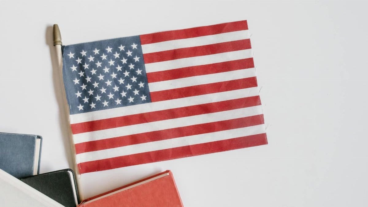 A flat lay image of an American flag with books on a white background, symbolizing patriotism and education.