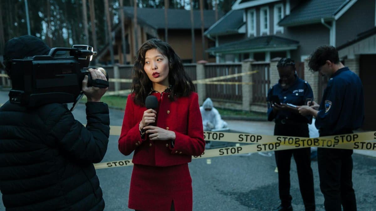 A journalist reporting from a crime scene with police officers and cameraman.