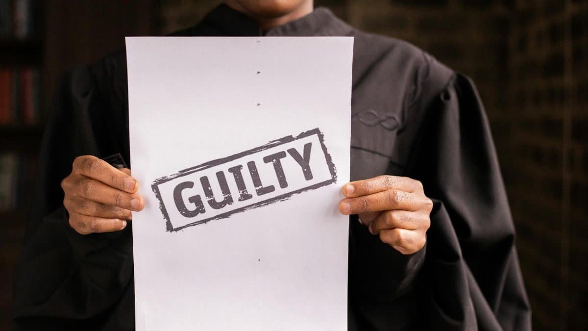 A judge in a courtroom holding a paper with a guilty verdict, symbolizing law and justice.