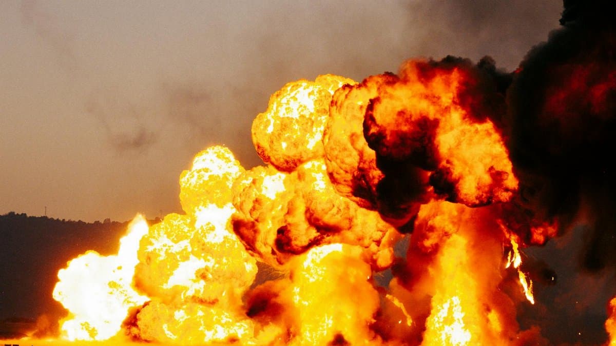 Powerful explosion with massive flames and smoke during daytime.