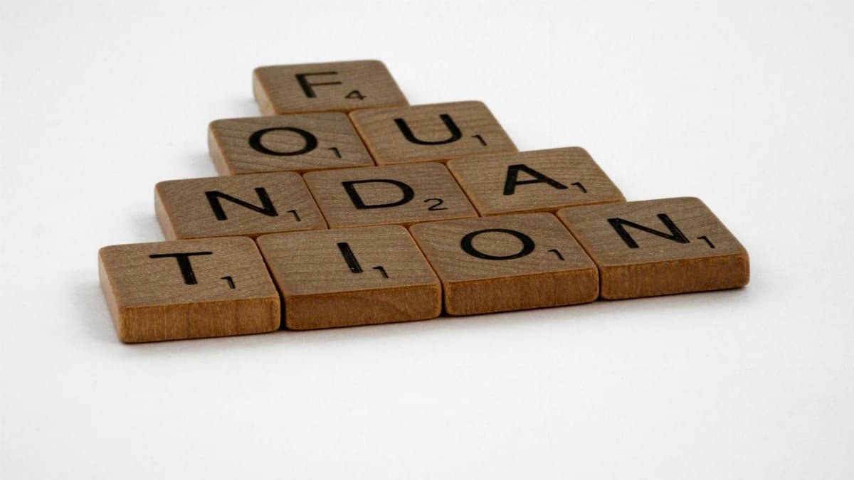 Scrabble tiles arranged to spell 'Foundation' on a white surface.