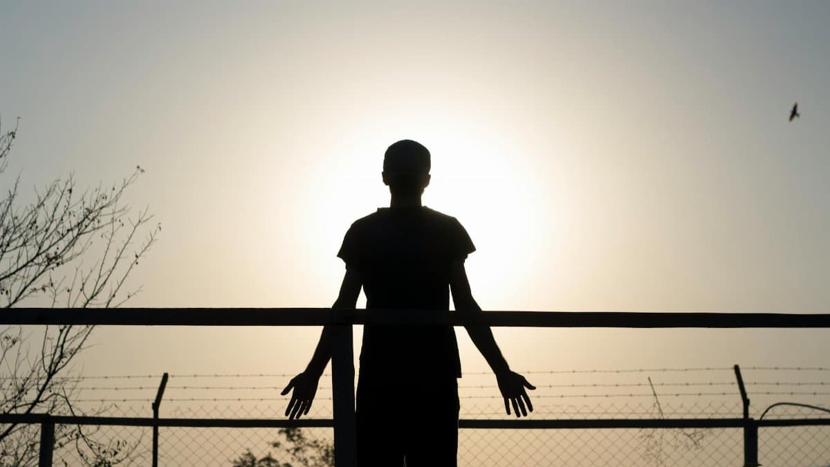Silhouette of a person at sunrise, symbolizing freedom and individuality, with a bird in the sky.