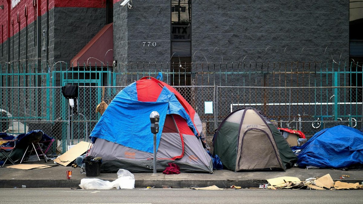 A view of tents set up on a sidewalk in Los Angeles, representing urban homelessness.