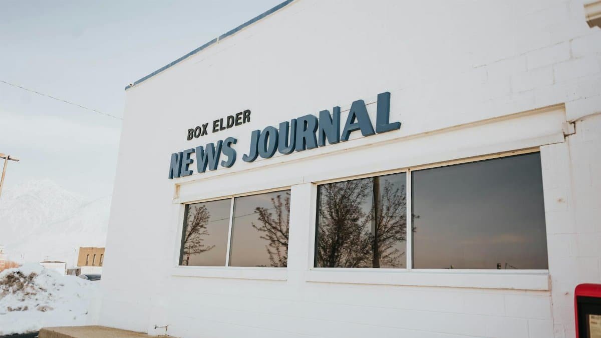 Exterior view of Box Elder News Journal with snowy surroundings and reflective windows.