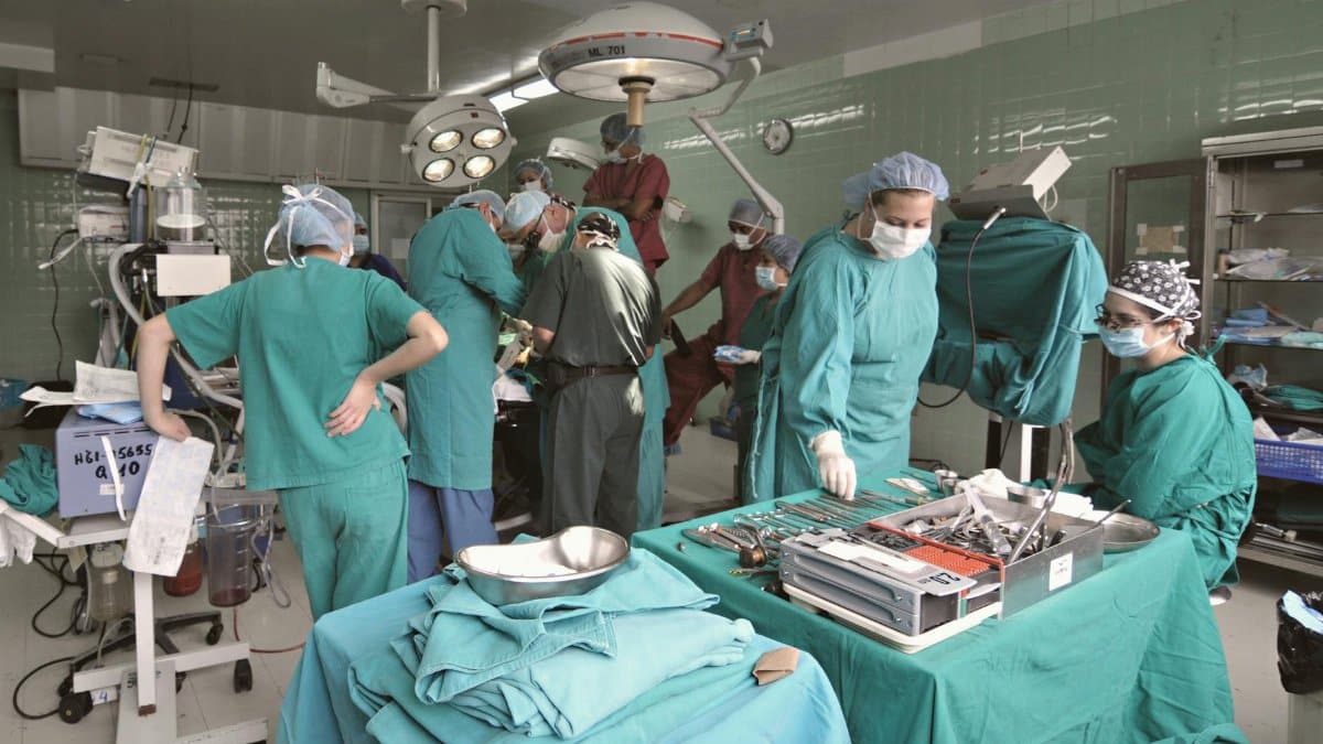 A surgical team performs an operation in a hospital operating room.