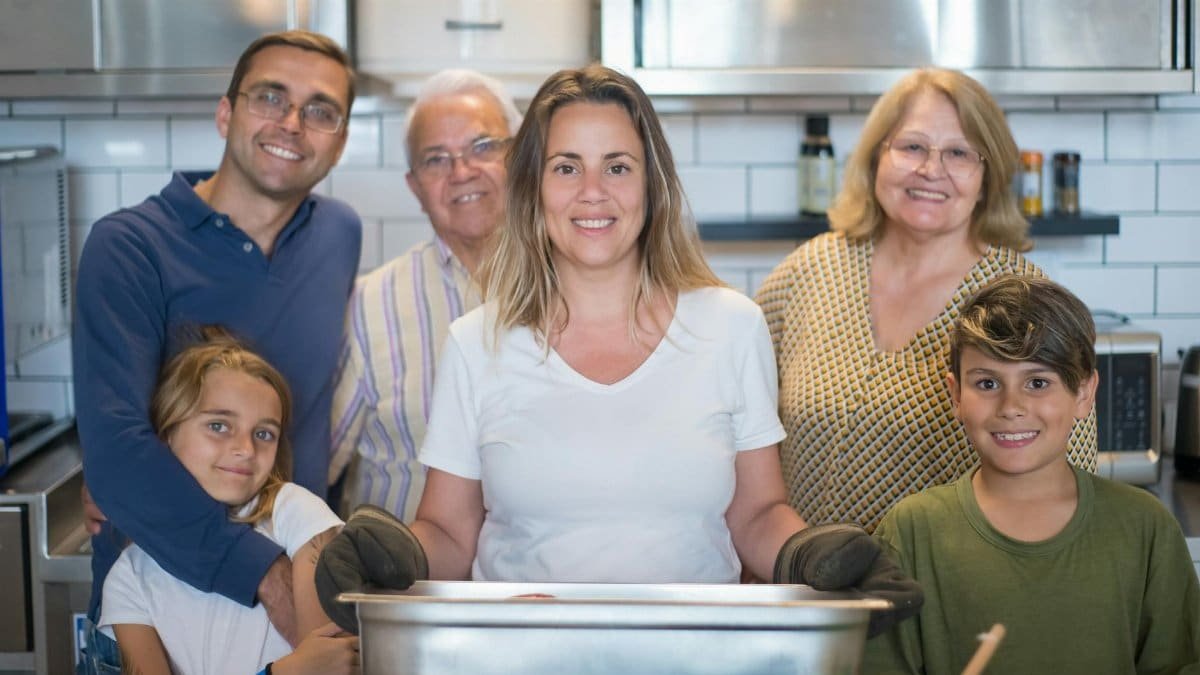A joyful multigenerational family gathering in the kitchen, sharing moments while cooking indoors.