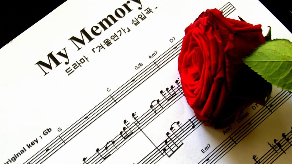 A red rose rests on sheet music titled 'My Memory', evoking romance and nostalgia.