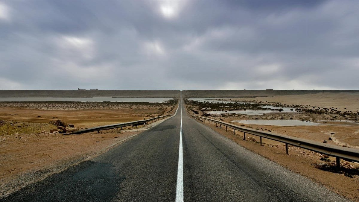 Long straight road through the desert landscape in Tan-Tan, Morocco.