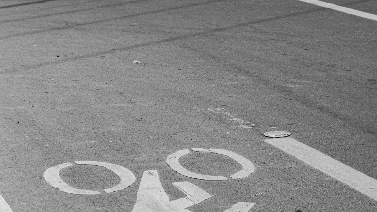 Monochrome image of bicycle lane symbols painted on an empty street.