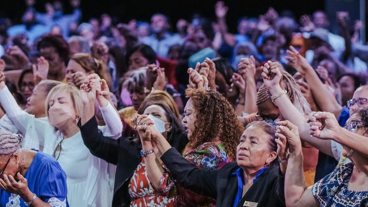 A diverse group of people in a heartfelt spiritual gathering, holding hands in unity.