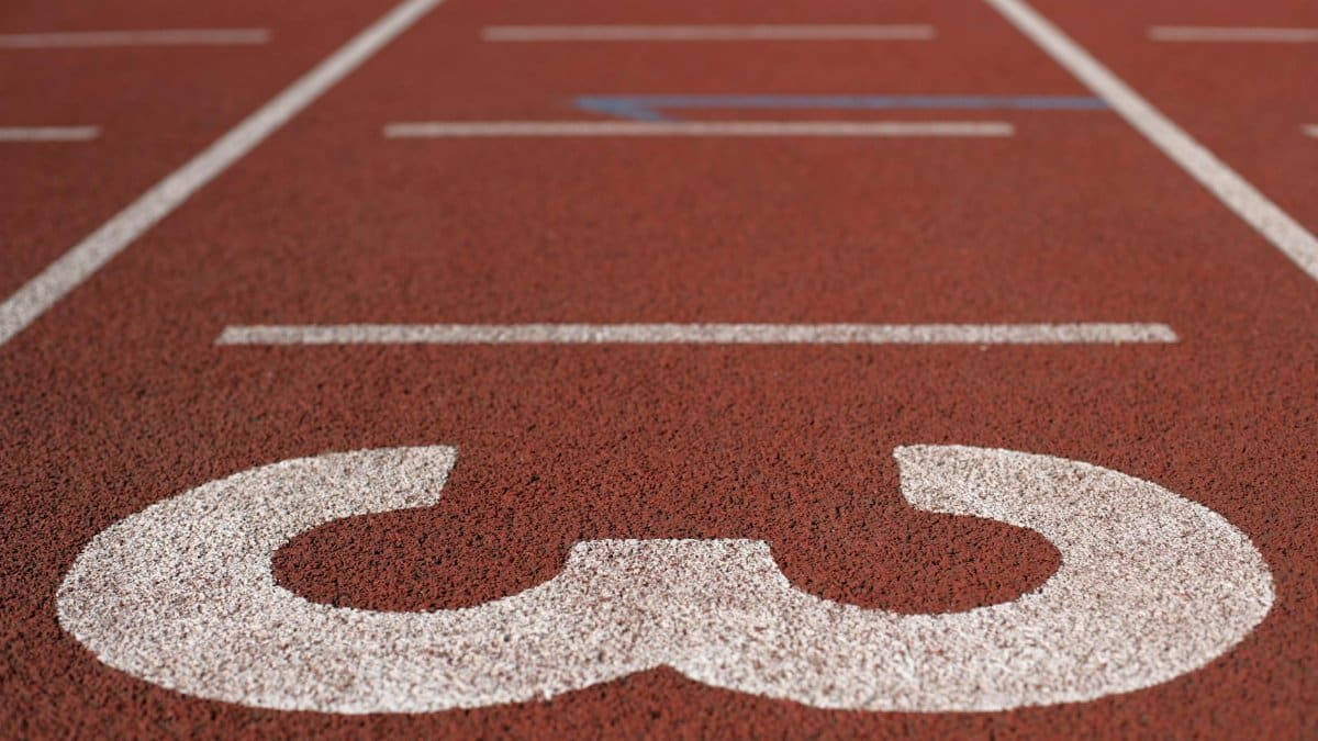 Detailed view of lane three on an outdoor athletic track highlighting the textured surface.