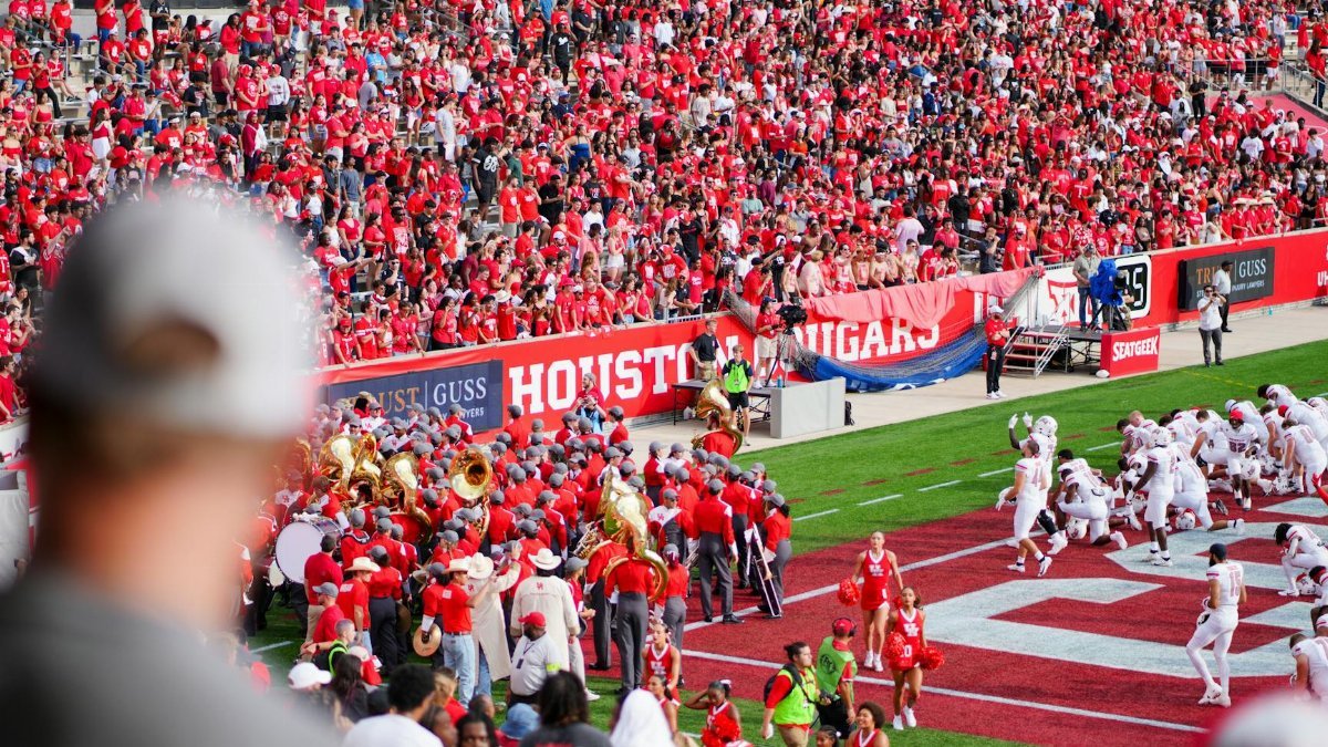 Cheerful fans at a college football game in Houston, TX, showcasing school spirit and vibrant energy.