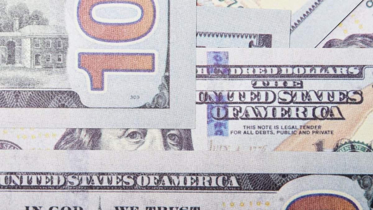 Detailed close-up of layered US dollar banknotes focusing on geometric patterns and financial concept.