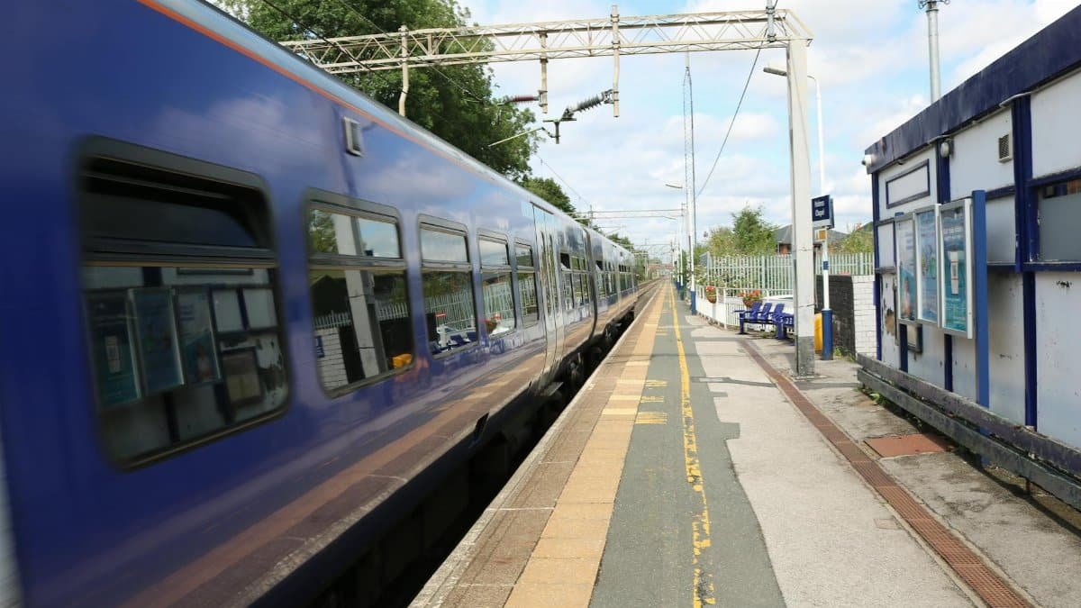 A fast-moving train at Holmes Chapel Station in England, capturing travel and motion.