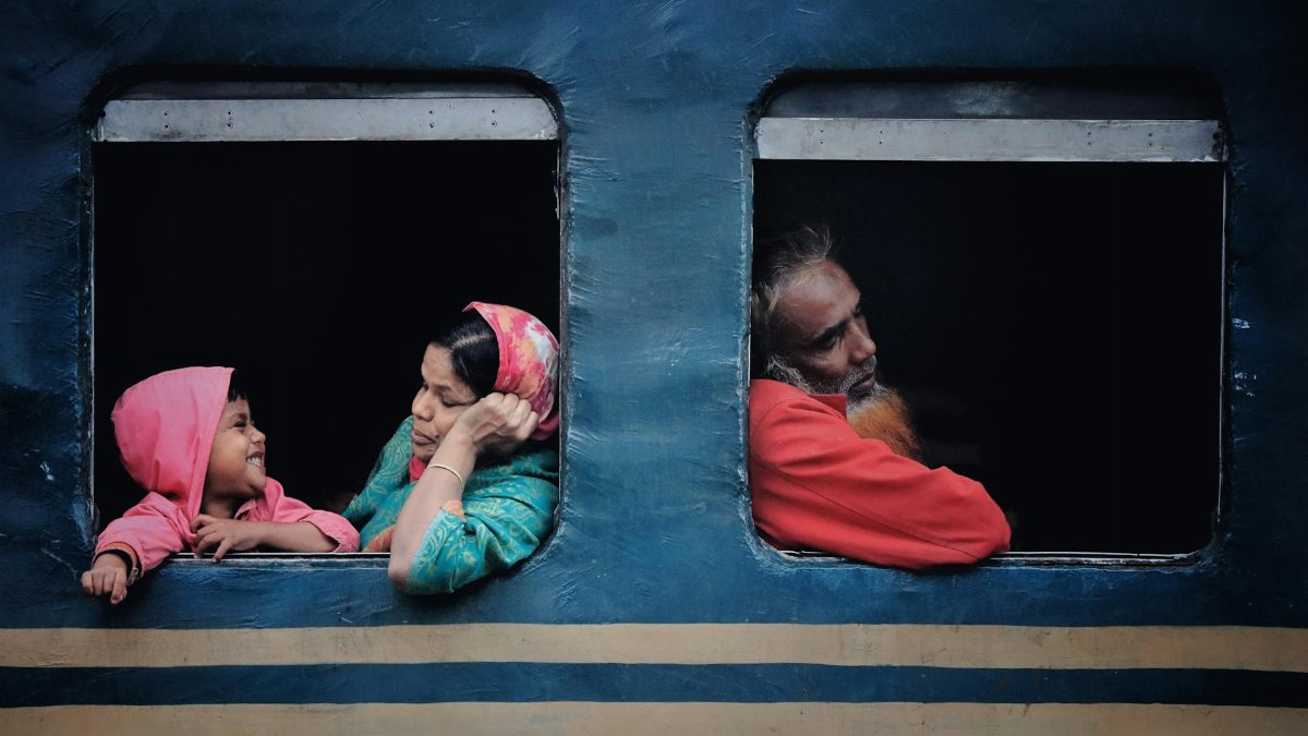A mother and child interact while traveling on a train, capturing a joyous moment.