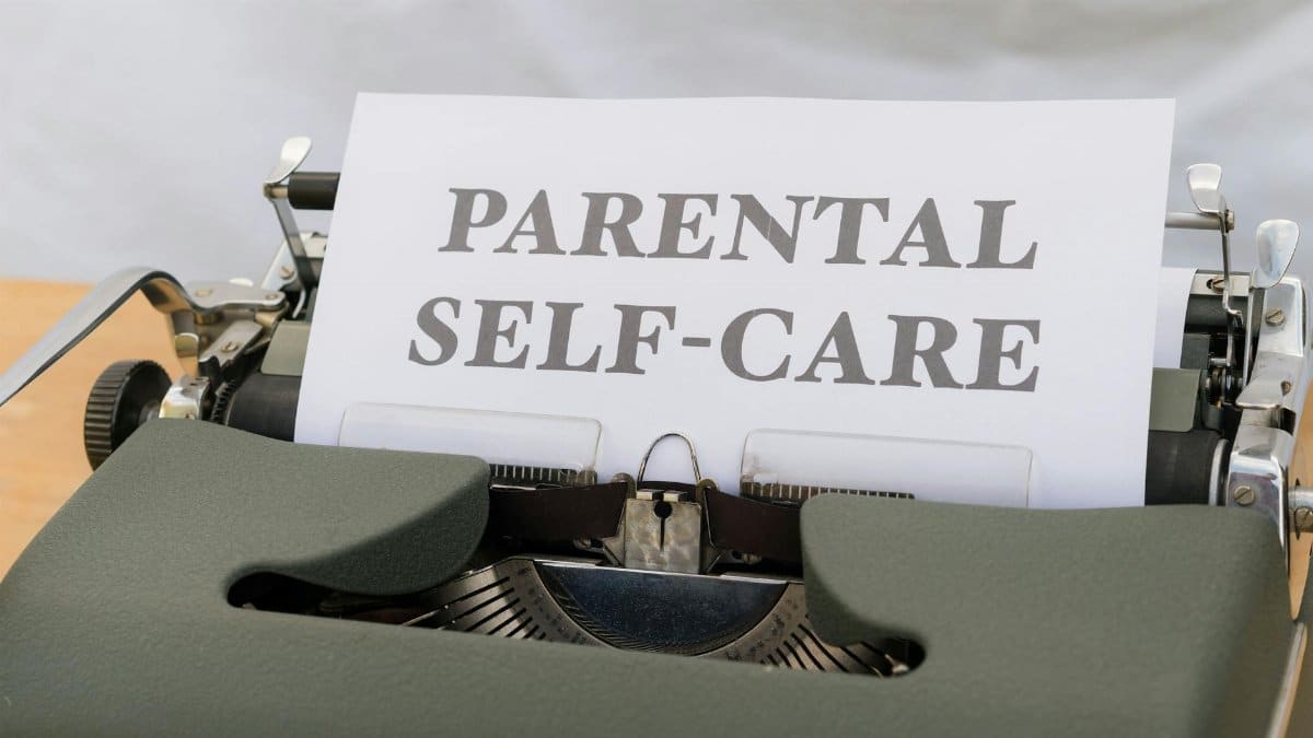 Close-up of a typewriter with the text 'Parental Self-Care.'