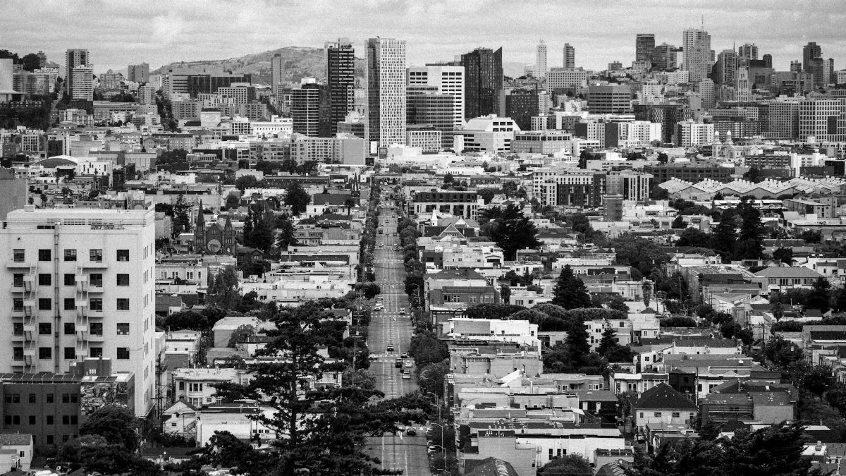 Dramatic black and white aerial view of San Francisco's skyline on a foggy day.