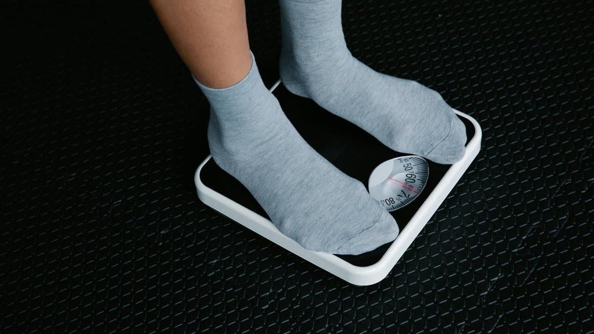 Close-up of feet in socks standing on a scale, focusing on weight measurement.