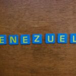 Blue and yellow letter tiles spelling Venezuela on a wooden surface.