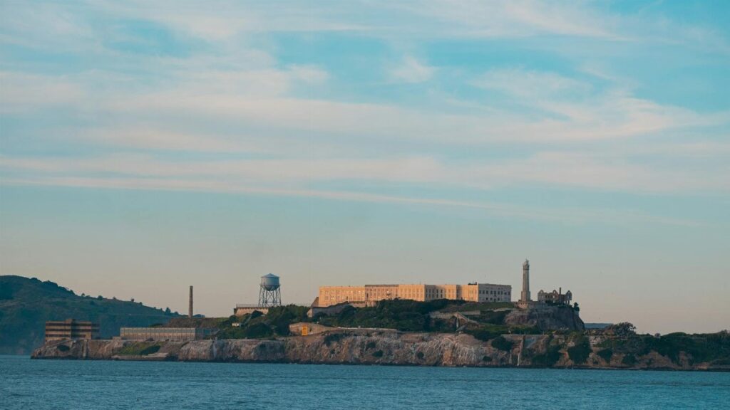 Distant view of the historic Alcatraz Island prison in San Francisco Bay under a clear sky.
