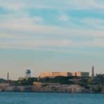 Distant view of the historic Alcatraz Island prison in San Francisco Bay under a clear sky.