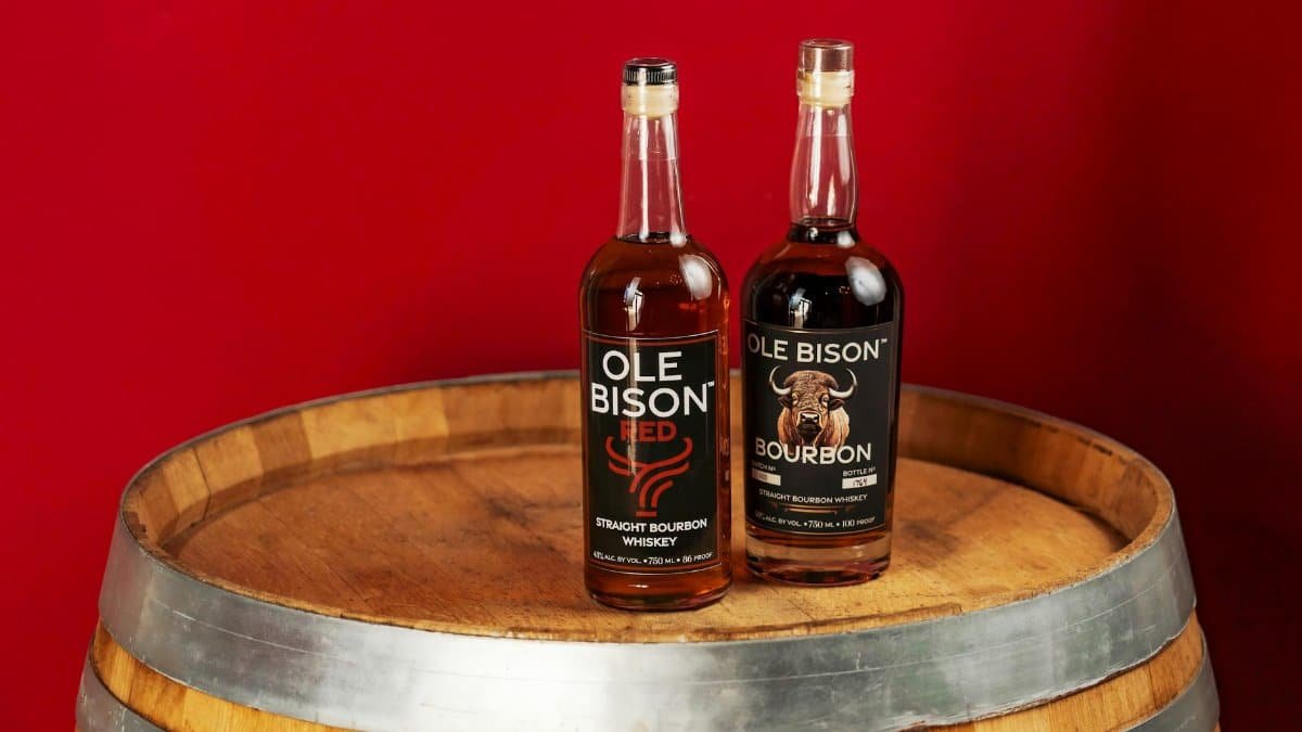 Two Ole Bison bourbon bottles on a barrel against a red background in New Orleans.