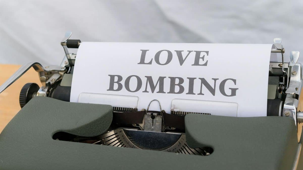 Close-up of a typewriter displaying the phrase 'Love Bombing' on paper.