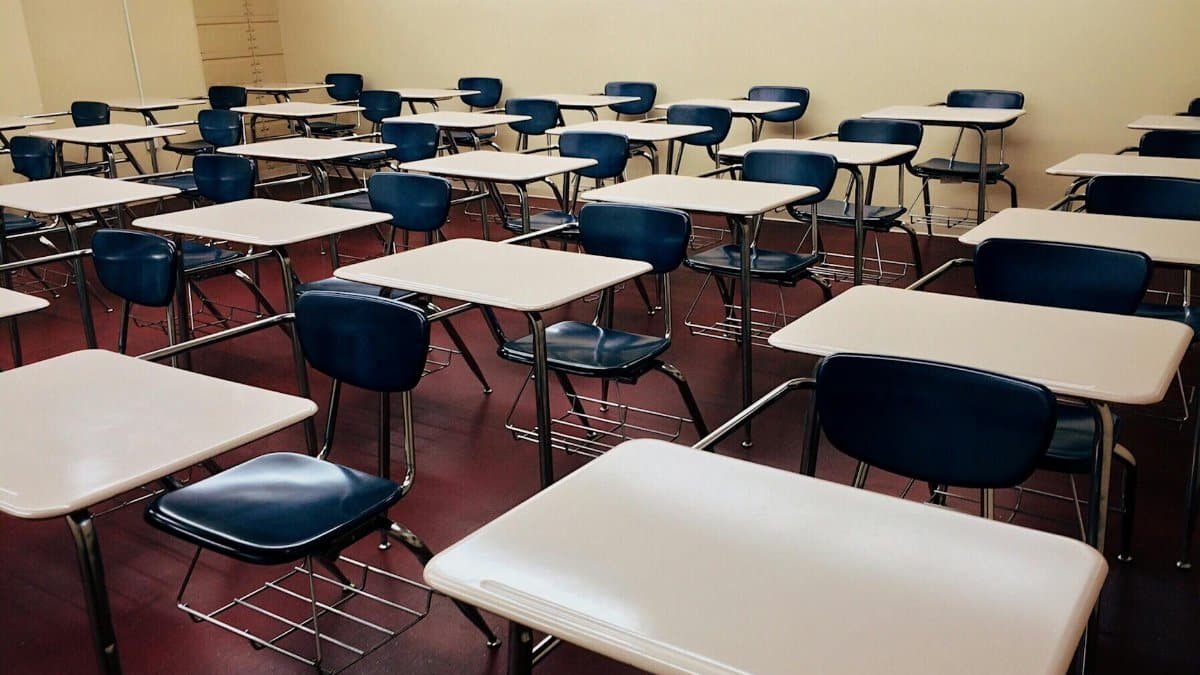 An empty classroom featuring neatly arranged desks and chairs ready for use.
