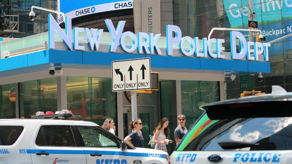 NYPD cars and people in front of New York Police Department building in Times Square.