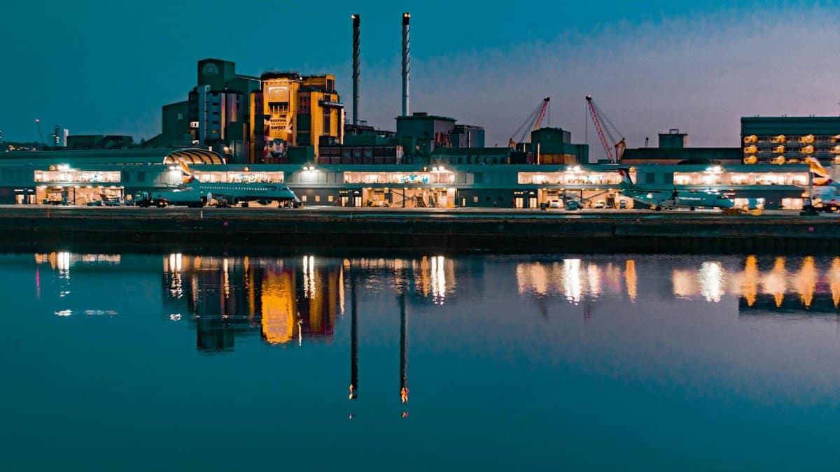 Illuminated skyline at night reflecting in the Thames near London City Airport.