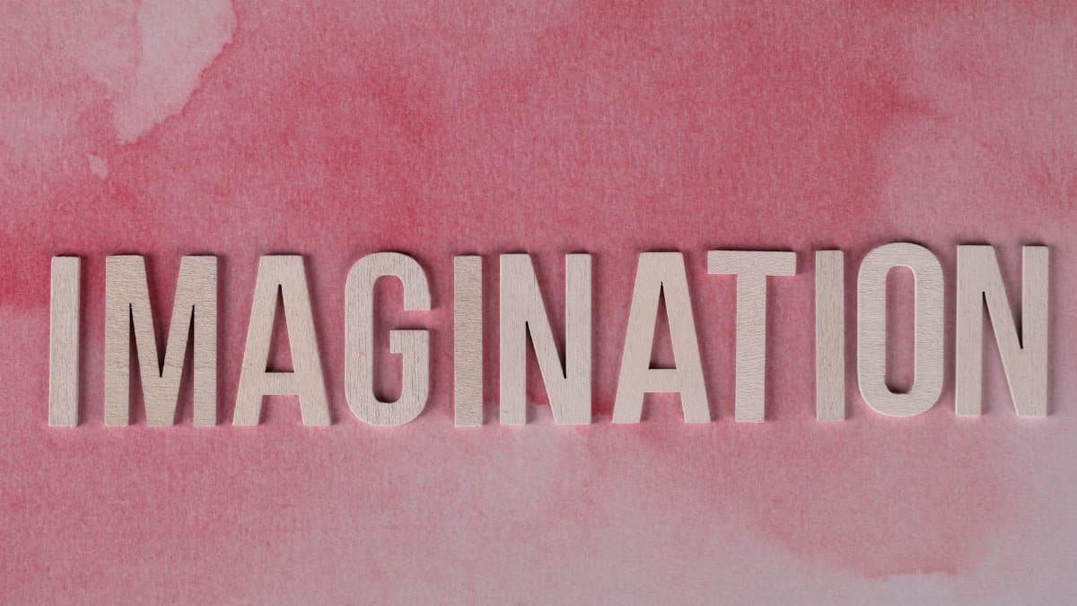 Inspiring Imagination text on pink watercolor background, symbolizing creativity and innovation.