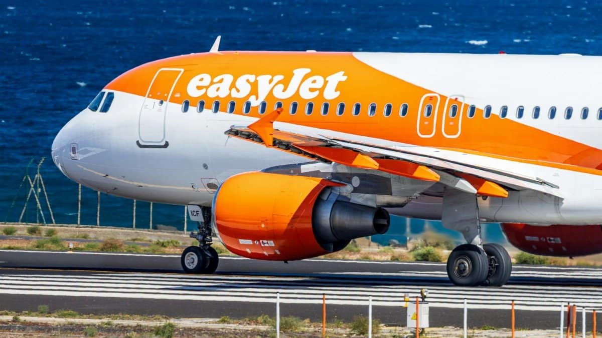 Close-up of EasyJet Airbus A320 landing on a runway by the sea in Spain.