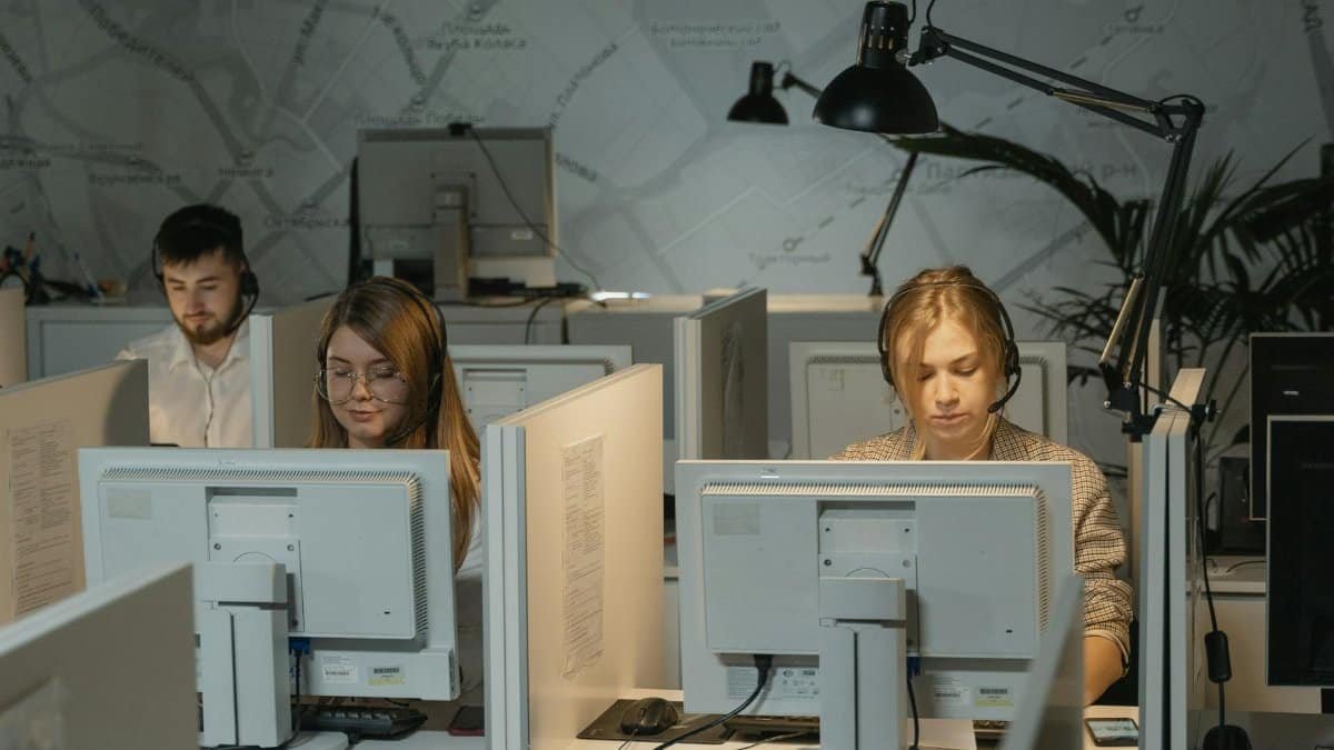 Call center agents working diligently with computers and headphones, providing customer support.