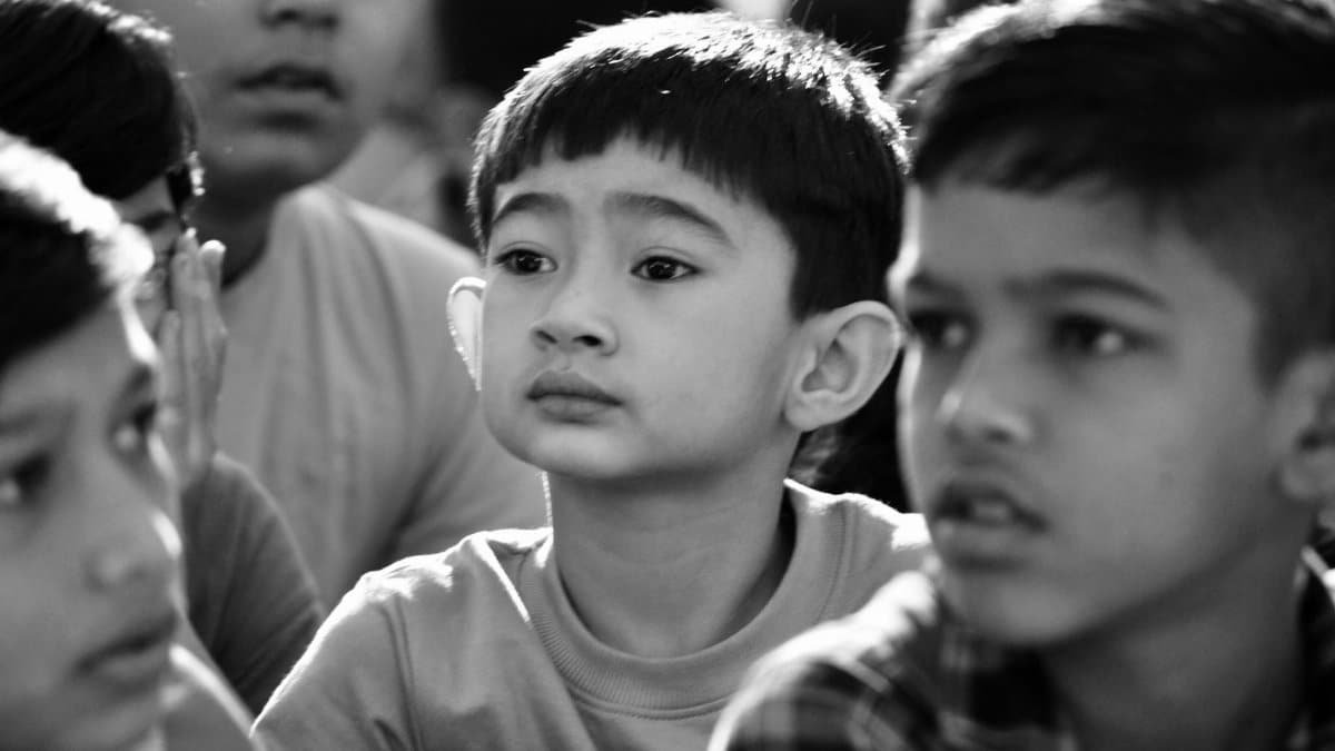Engaged group of children in a thoughtful moment captured in black and white.