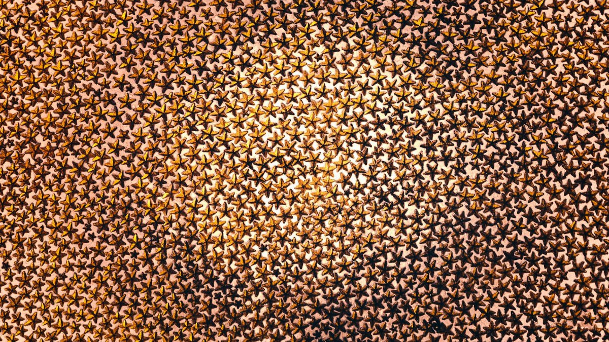 A captivating abstract pattern featuring an abundance of golden star designs creating a mesmerizing visual effect.
